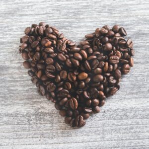A heart made out of coffee beans on top of a table.